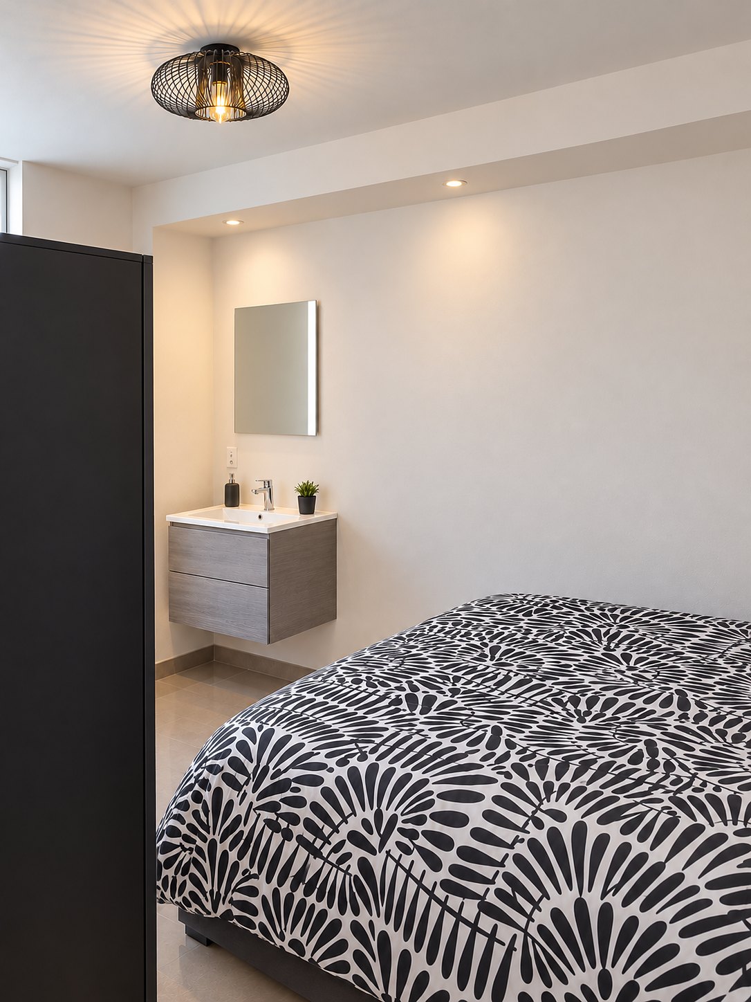 La chambre noire : lit double, évier avec miroir et armoire
